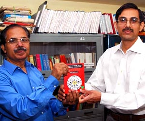 Kev Nair handing over a copy of the book 'Bhagavad Gita of Inner Courage' to Rajeev Vasudev, former chief executive officer of Technopark.