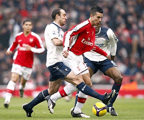 Arsenal's Robin Van Persie, center, is challenged by Bolton Wanderers' Gavin McCann (Photo: AP)