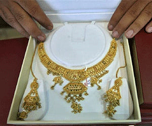 A shopkeeper displays gold jewellery inside his showroom in Jammu (Photo: Reuters)