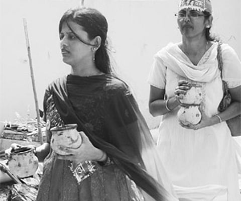 Jain women carry pots of water collected from the Krishna to perform a ritual at the Sivalingam in Vijayawada on Sunday.