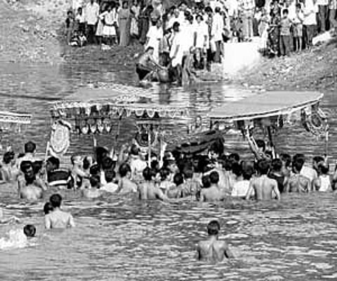 Devotees take out the idol of Lord Narayan Gosain from the pond near Gosain temple in Jajpur.