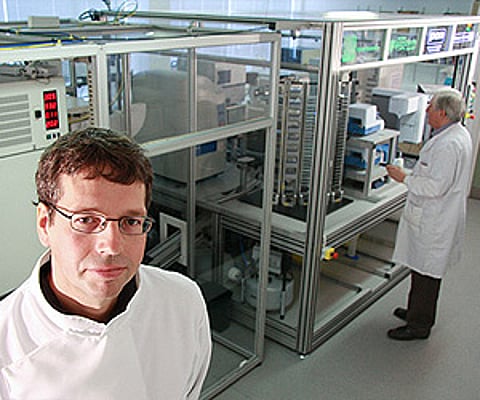 Adam (shown in background) with its two human 'colleagues' in the white coats. (Image courtesy: Aberystwyth University)