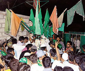 People rushing towards the flag pole in front of Hazrath Sadiq Ali Shah Hussaini (R A) Dargah in Bangalore on Wednesday.