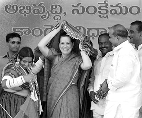 A Lambada woman presenting their traditional dress to Congress president Sonia Gandhi at the public meeting in Kothagudem on Friday. Chief Minister Y.
