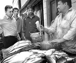 A fish-seller on the busy JC Nagar Main Road wooing customers.