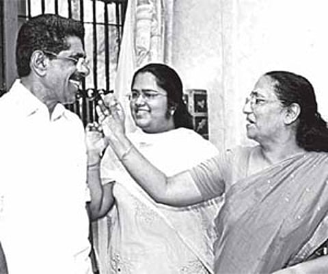 Usha Ramachandran giving sweets to Mullappally as daughter Parvathy looks on in New Delhi on Wednesday.