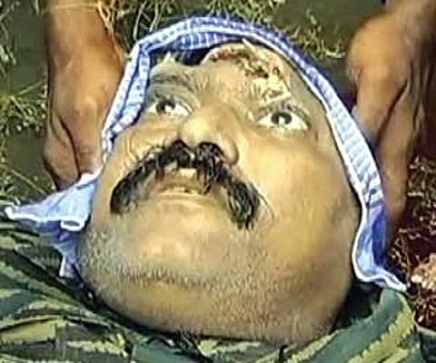 In this image taken from undated handout video footage released by Sri Lankan army on Tuesday, soldiers display the body of a man they claim is slain