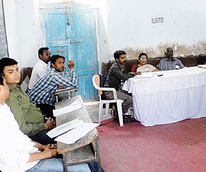WHERE IS EVERYONE? Polling officials wait for voters to come and cast their votes at a booth in the city during the GHMC elections on Monday.