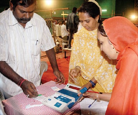 Poll officials count the votes polled in one of the EVMs.
