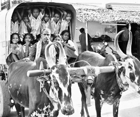 Children going to school on bullock cart caravan in Palayamkottai