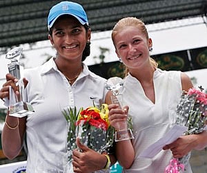 Poojashree Venkatesha and Dalila Jakupovic display their trophies after the final match of the ITF Women's Open tourney in Bangalore on Saturday. (AP)