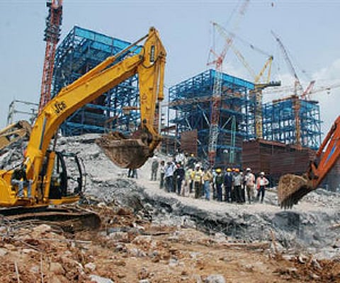 Rescue workers stand at the site of a collapsed chimney of a power plant that belongs to Balco in Chhattisgarh September 24, 2009. (Reuters)