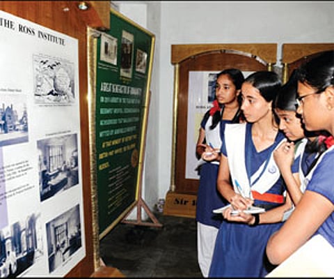 Students jotting down points from a display at the Ronald Ross Museum at Begumpet on Friday.