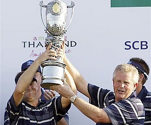 Europe team members Alexander Noren of Sweden, left, and Colin Montgomerie, captain of the European team, hold the Royal Trophy in Chonburi. AP