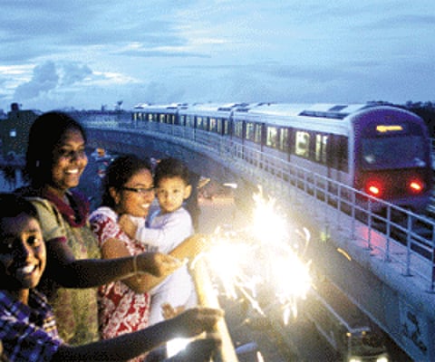 FESTIVE RUN: A family celebrates Deepavali with sparklers while a Metro train chugs past them at Indiranagar in Bangalore on Thursday evening | Suresh