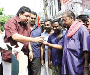 Labour Minister Shibu Baby John distributing cakes to headload workers of the Palayam market for refusing to accept ‘nokkukooli’ on Thursday |EPS
