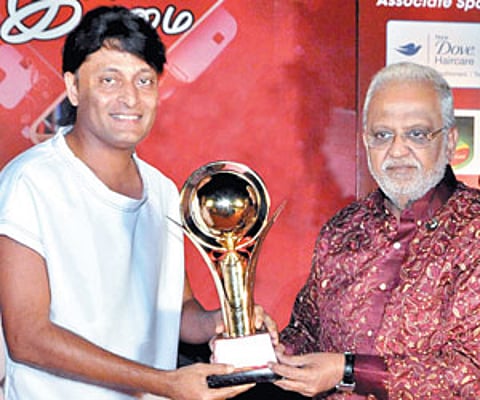 Boby Chemmanur receiving the award from singer SP Balasubramaniam at the event.