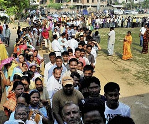 People queue up to cast their votes during the 2nd phase of Assam assembly elections at Bagharbori in Dispur on Monday. (PTI)