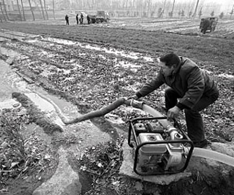 A Chinese farmer watering his drought-stricken wheat field in Luoyang, north China’s Henan province.