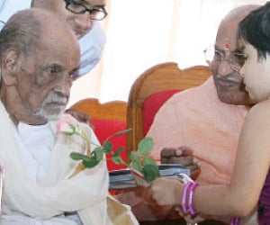 A little girl offering a rose flower to Sanskrit scholar M H Shastri at the function held to celebrate his 100th birthday.(EPS)