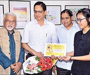 Margaret Samte receives the award for the best budding cartoonist from Amarnath Kamath.