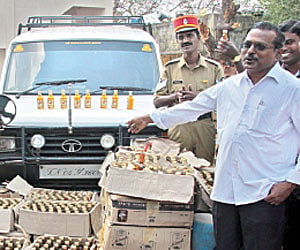 Excise officials and police with the liquor bottles that were seized at Transport City near Mettupalayam, Puducherry - G Pattabiraman/ Express