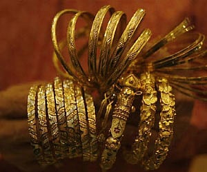 A jewellery shop owner counts gold bangles after displaying them to a customer at a jewellery shop in Kolkata. (File photo/Reuters)