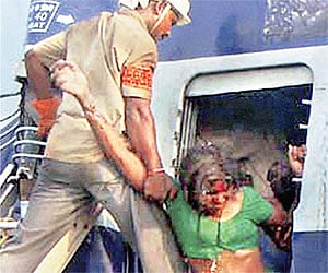 A policeman rescues a woman from the wreckage of the Hampi Express at Penukonda. PTI Photo