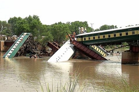 Cars of a passenger train fall after a bridge collapse led a train into a canal in Wazirabad, near Lahore, Pakistan Friday, July 3, 2015. Pakistan's military said Friday the death toll from an accident to a special train that plunged into a canal because