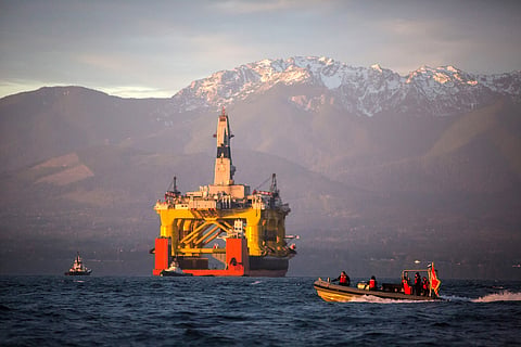 FILE - In this April 17, 2015 file photo, with the Olympic Mountains in the background, a small boat crosses in front of the Transocean Polar Pioneer, a semi-submersible drilling unit that Royal Dutch Shell leases from Transocean Ltd., as it arrives in Po