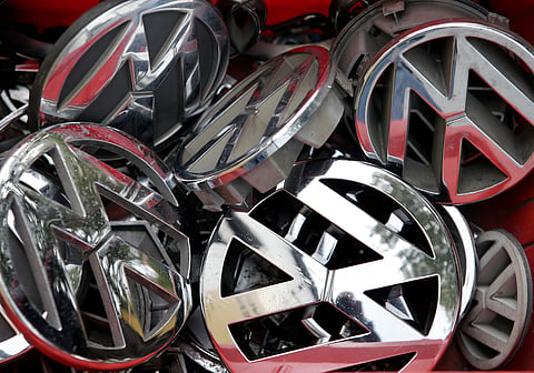 In this Sept. 23, 2015 file photo, company logos of the German car manufacturer Volkswagen sit in a box at a scrap yard