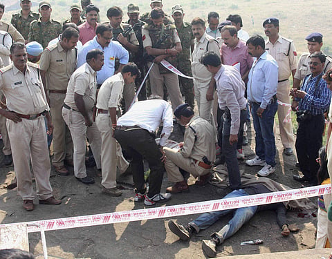 Police investigate the encounter site at the hillocks of Acharpura village where 8 SIMI activists were encountered. | PTI