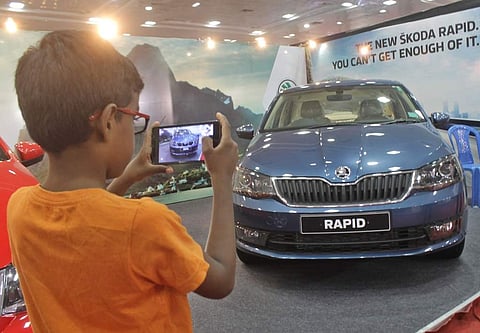 A young visitor to the Express Auto Expo on Saturday clicks a snap of Skoda Rapid. The two-day expo showcases both Indian and foreign auto brands. (Photo | Ashwin Prasath)