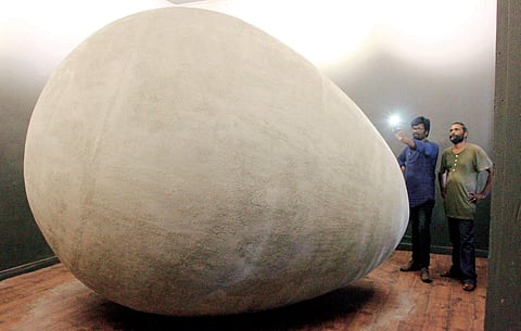 A visitor taking a photograph of the installation titled Garbh, a giant egg-shaped sculpture put on exhibition at the Kochi-Muziris Biennale on Tuesday | Albin Mathew