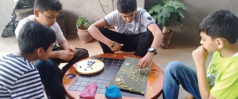 Children playing ancient board game Tigers and Goats