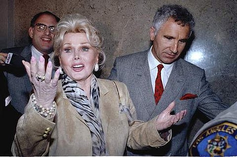 In a May 1, 1990 file photo, Zsa Zsa Gabor gestures as she leaves a Beverly Hills courtroom where a judge ruled that she violated her probation. (AP)