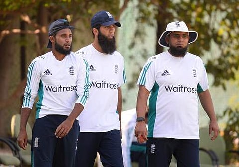 England's cricketer Adil Rashid, Moeen Ali, and bowling coach Saqlain Mushtaq walk towards the nets during a training session at the Punjab Cricket Association Stadium in Mohali. | AFP