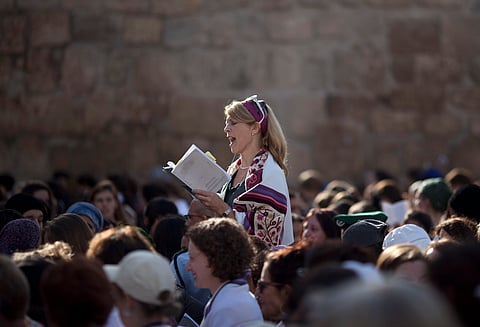 In this Monday, Nov. 4, 2013, file photo, a Jewish woman wears a prayer shawl as she prays at the Western Wall, the holiest site where Jews can pray in Jerusalem's Old City. Israeli Prime Minister Benjamin Netanyahu is advancing a plan to allow non-Ortho