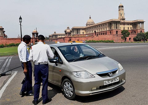 Traffic police men slap a challan to a commuter for riding with number plate ending with an even digit in New Delhi on Friday on the first day of the second phase of Delhi government s odd-even road rationing scheme. |PTI