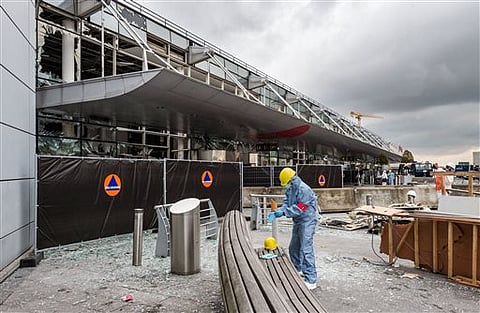 A forensics officer works in front of the damaged Zaventem Airport terminal in Brussels. |AP