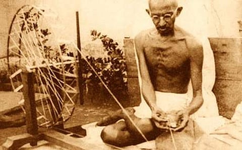 Mahatma Gandhi spinning yarn, in late 1920 (Image courtesy Wikimedia Commons)