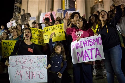 Demonstrators protest the gang rape of a 16-year-old girl in Rio de Janeiro, Brazil, May 27, 2016. Their signs read in Portuguese: "Save our girls," left, and "Machismo kills." The assault last Saturday came to light after several men joked about the