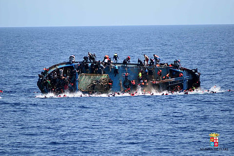 People try to jump in the water right before their boat overturns off the Libyan coast.
