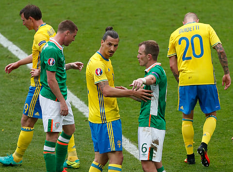 Republic of Ireland's Glenn Whelan, second right, talks to Sweden's Zlatan Ibrahimovic after Whelan received a yellow card during the Euro 2016 Group E soccer match between Ireland and Sweden at the Stade de France in Saint-Denis, north of Paris, France