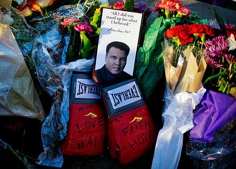 Boxing gloves and a message sit among flowers at a makeshift memorial to Muhammad Ali at the Muhammad Ali Center. |AP