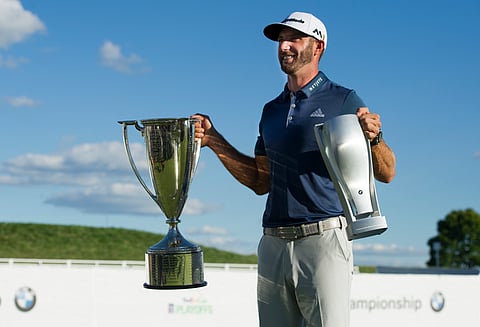 Dustin Johnson poses with his trophies after winning the BMW Championship golf tournament at Crooked Stick Golf Club in Carmel, Ind., Sunday, Sept. 11, 2016. | AP