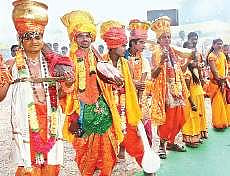 Haridasus sporting a dhoti and a Tanpura in hand, sing and dance at A Convention Centre in Vijayawada on Friday | Express