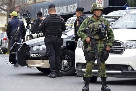 A soldier and police stand guard outside at a private school in Monterrey, Mexico, Wednesday, Jan. 18, 2016. A 15-year-old student opened fire with a gun at the school, hitting a teacher and two other students in the head before killing himself.(Photo | A