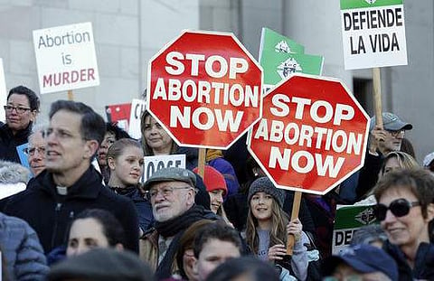 Participants in an anti-abortion rally hold signs that read 'Stop Abortion Now' as they listen to speakers on January 23 in Washington. (Photo | AP)