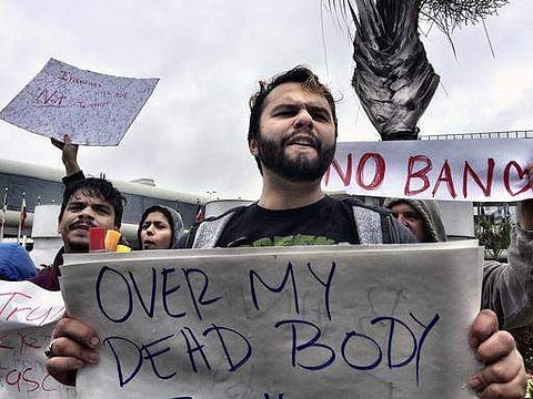 Franklyn Saumell protests against President Trump's refugee ban at Miami International Airport on Sunday | AP